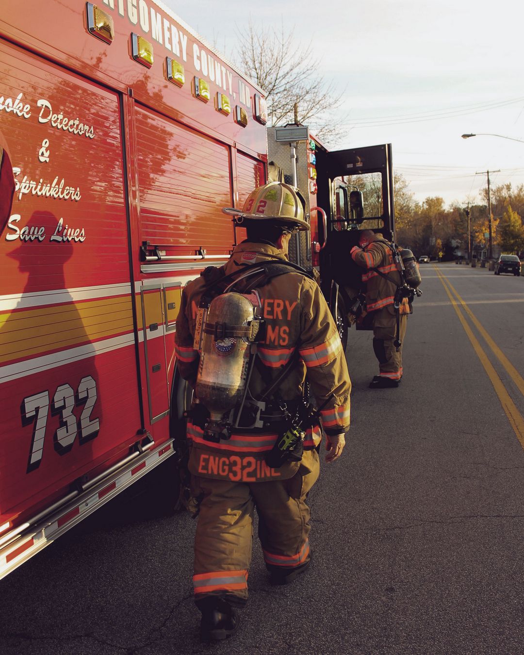 Firefighters walking alongside a fire engine
